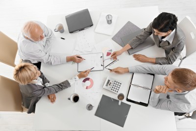 4 people at work table working 