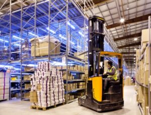 worker in forklift lifting boxes in an international warehouse 