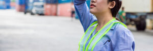 Female warehouse worker wiping away sweat while working on a hot summer day