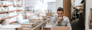 Man on computer at E-commerce warehouse