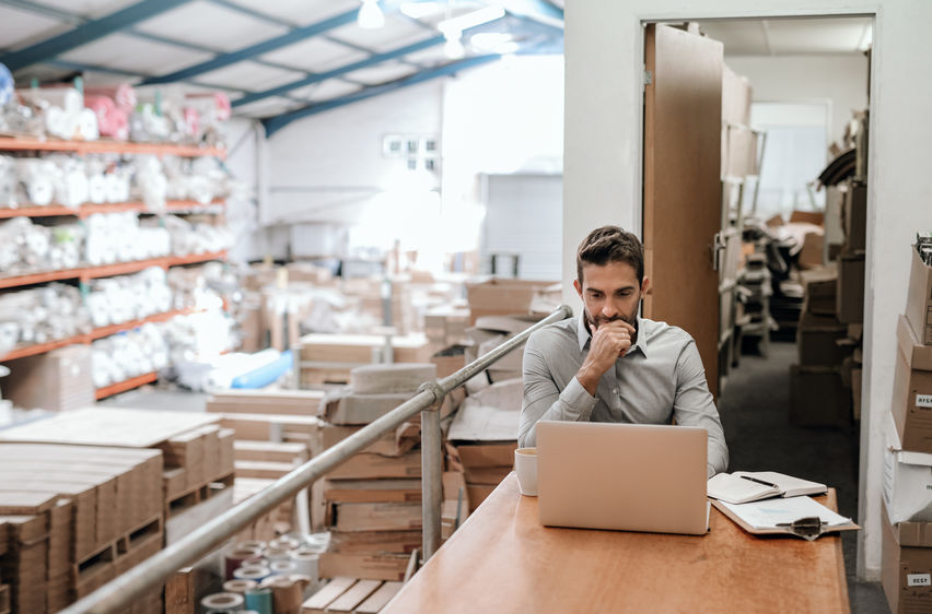 Man on computer at E-commerce warehouse 