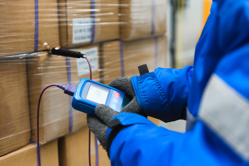 Warehouse Worker Using Thermometer 