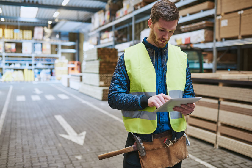 Young warehouse worker consulting a tablet