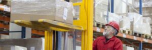 Worker lifting pallet at warehouse