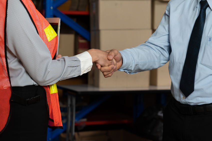 Warehouse worker shaking hands with client