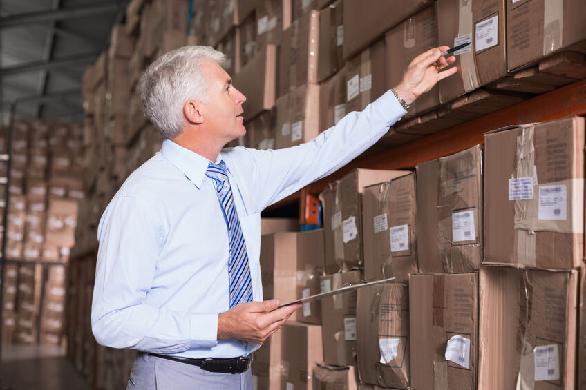 Warehouse manager checking his inventory in a large warehouse