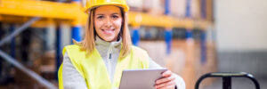 Young woman holding inventory tablet while working at warehouse