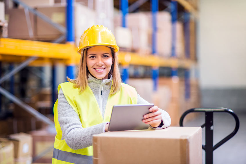 Young woman holding inventory tablet while working at warehouse