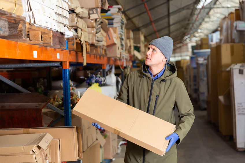 Man holding box in freezer warehouse