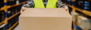 Close-up of warehouse worker packaging goods in warehouse.