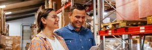 Smiling man and woman in warehouse looking at lease document